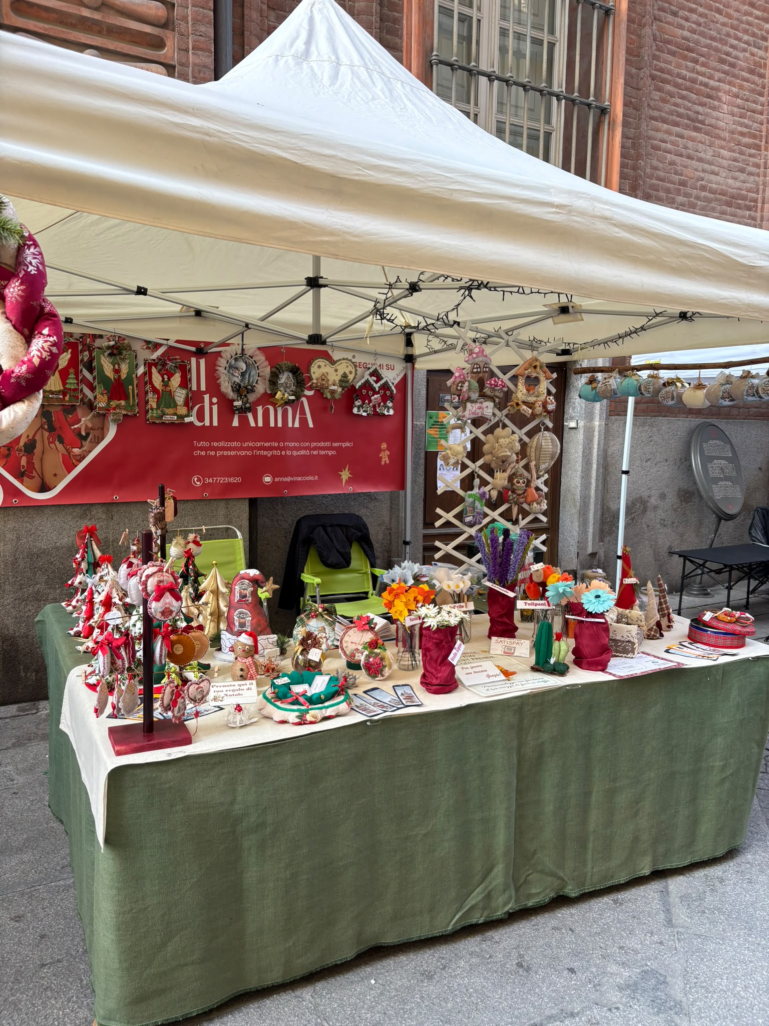 Il banco di Anna ricco di decorazioni artigianali a un mercatino